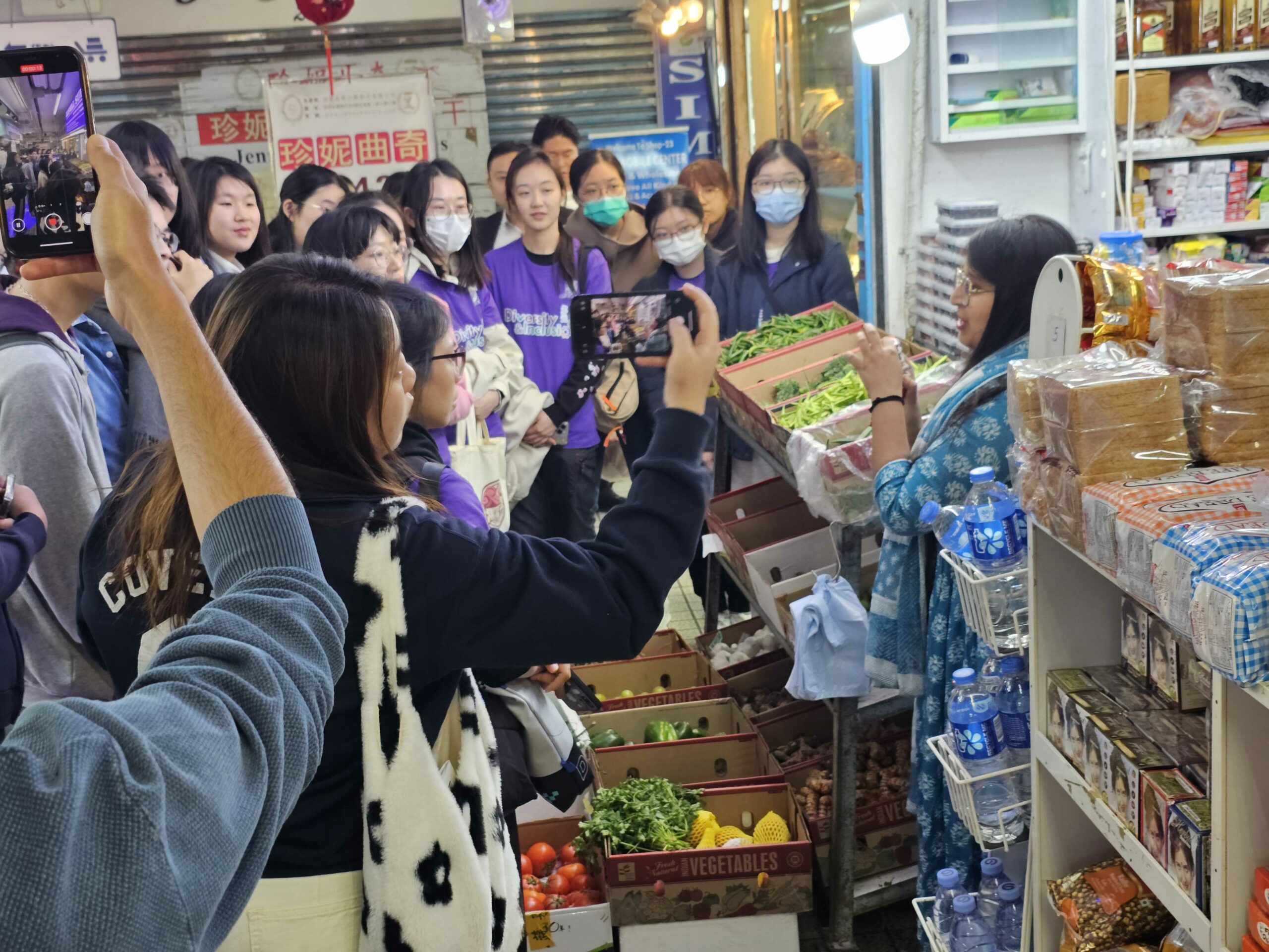 The D&I ambassadors are listening to the instructors' sharing at the South Asian grocery store.