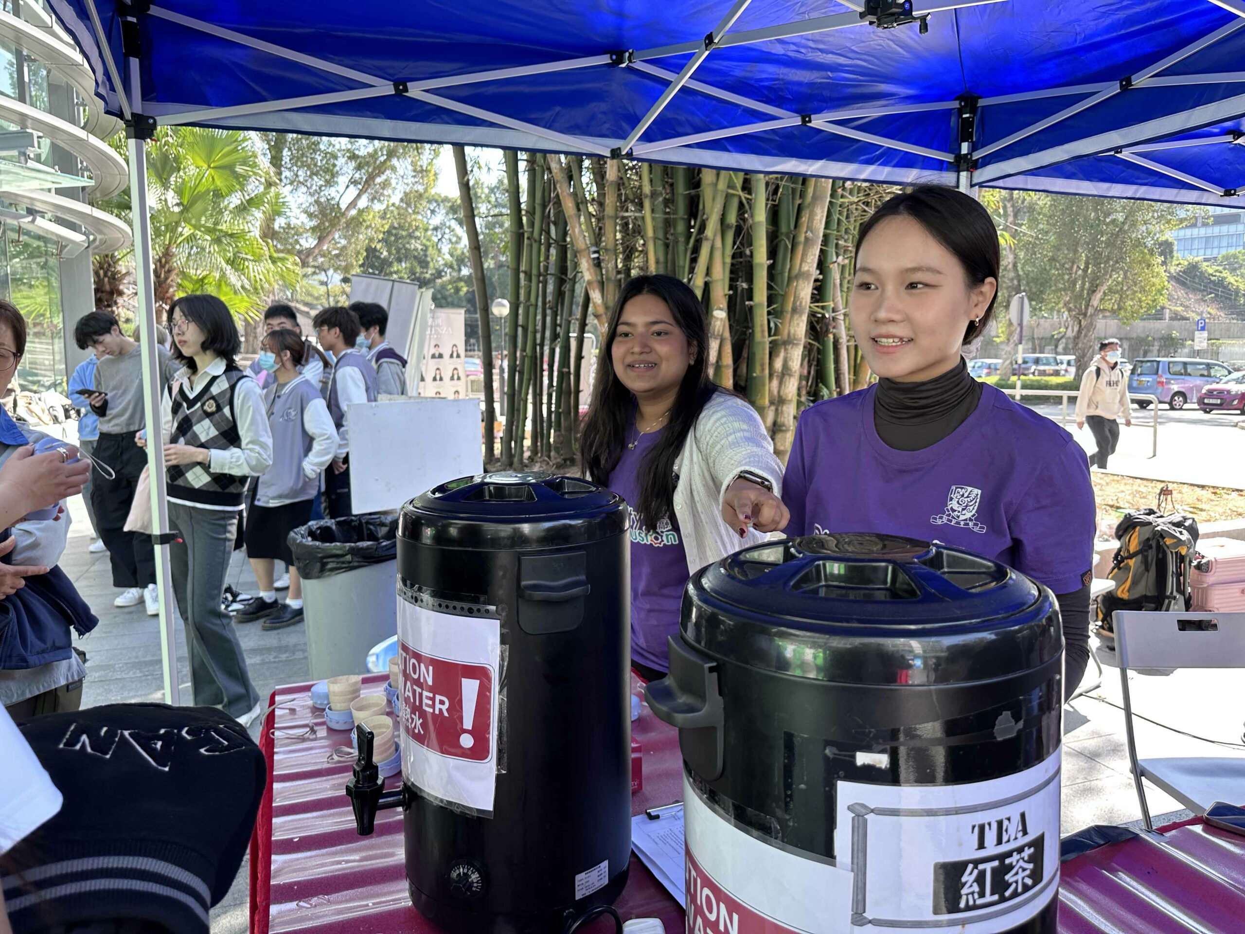 Two D&I ambassadors are preparing Hong Kong-style milk tea at the booth.